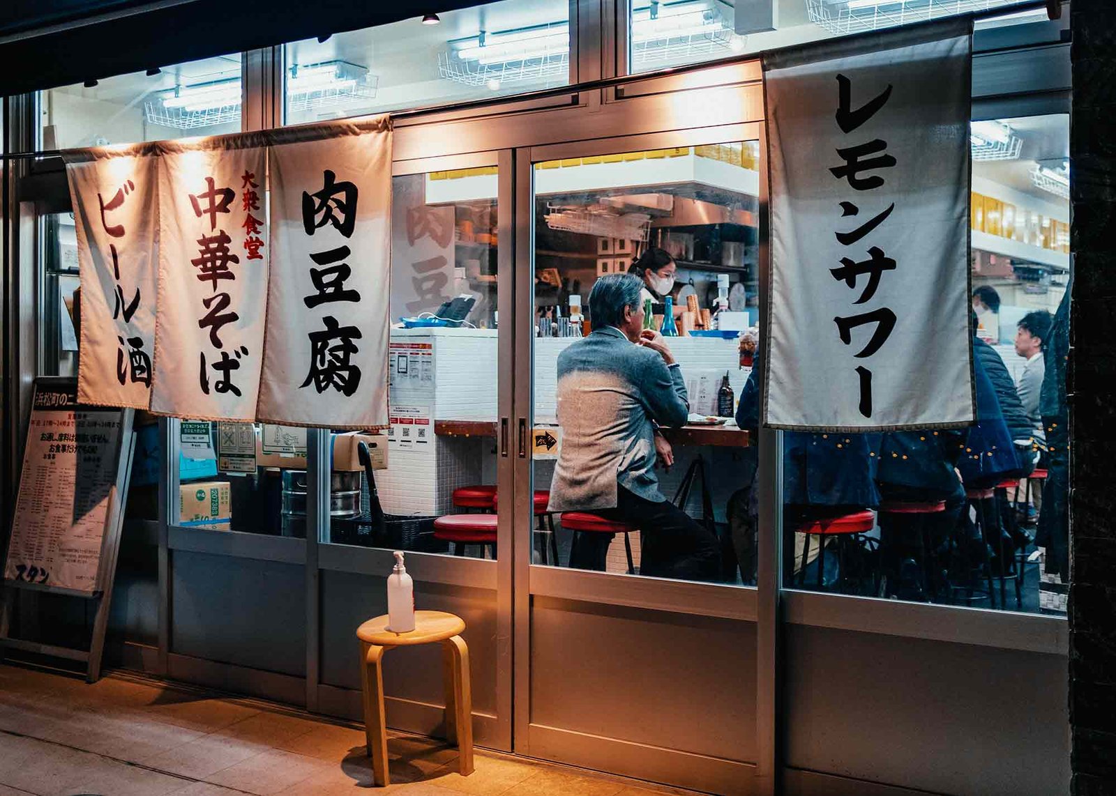 Authentic Japanese restaurant with noren curtains and COVID-19 safety measures.