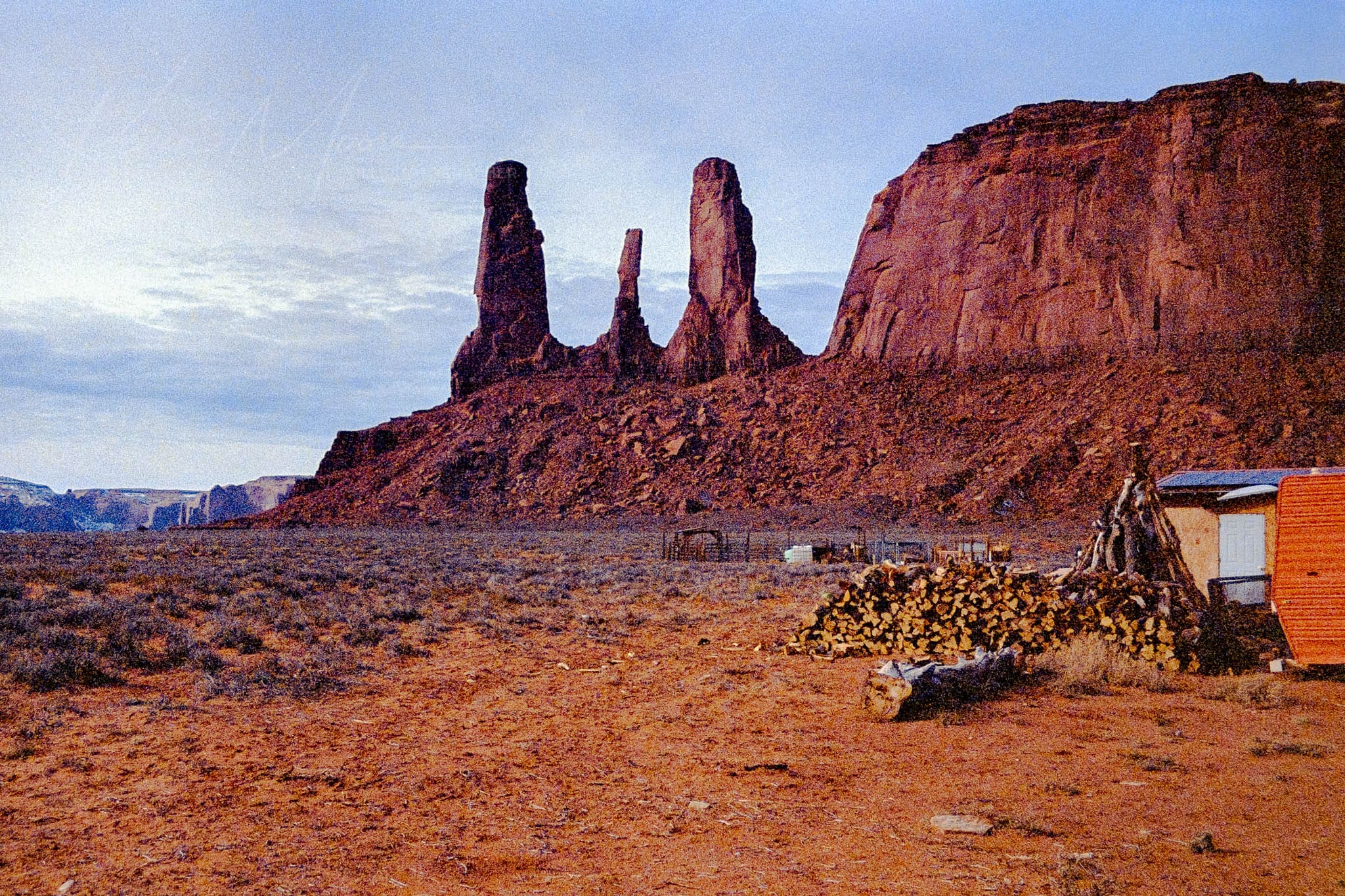Desert landscape at dusk with buttes and small building in the American Southwest.
