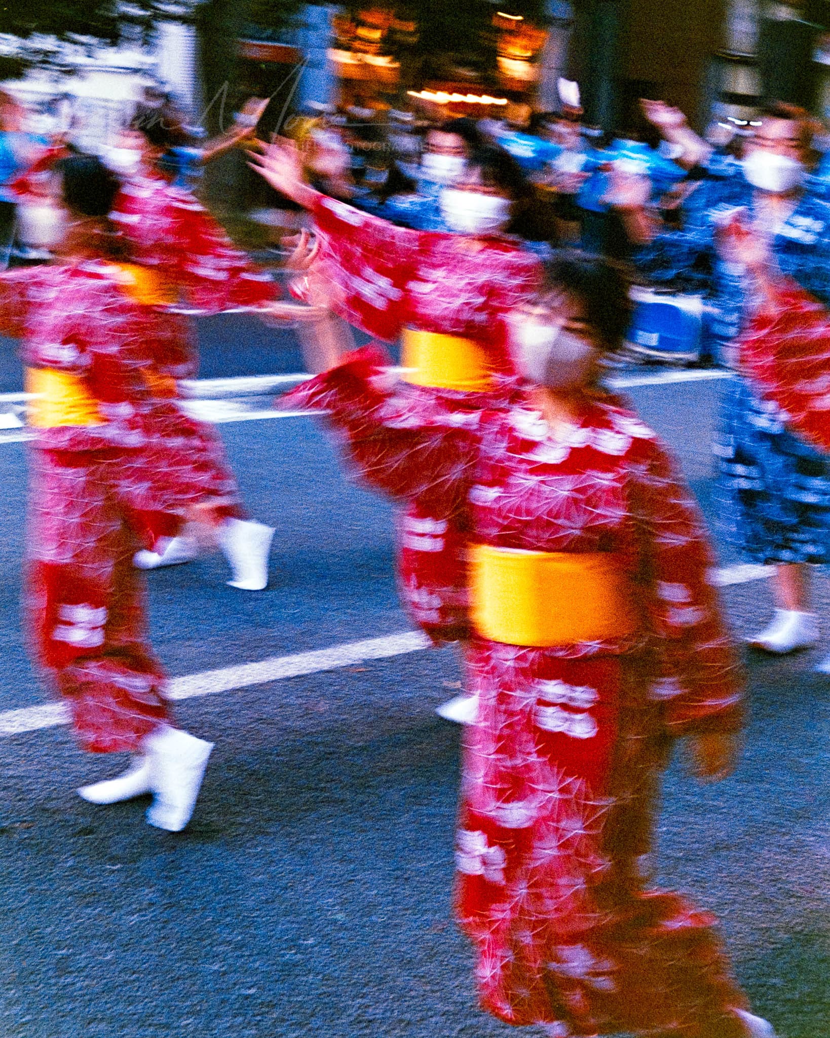 Japanese festival dancers in vibrant yukatas performing synchronized dance in urban setting.