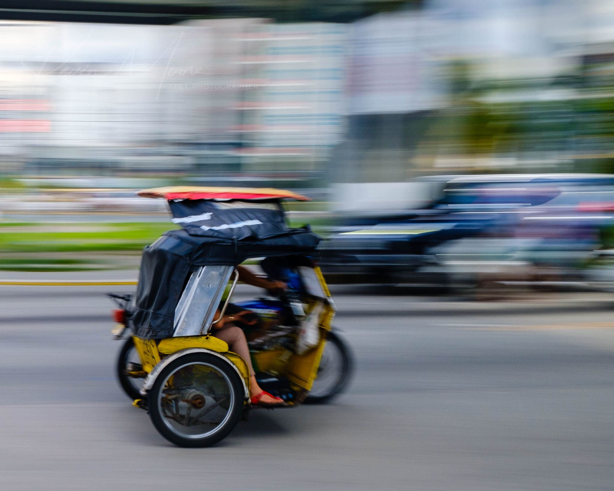 Yellow Trike speeding through blurred cityscape, signifying urban hustle in motion.