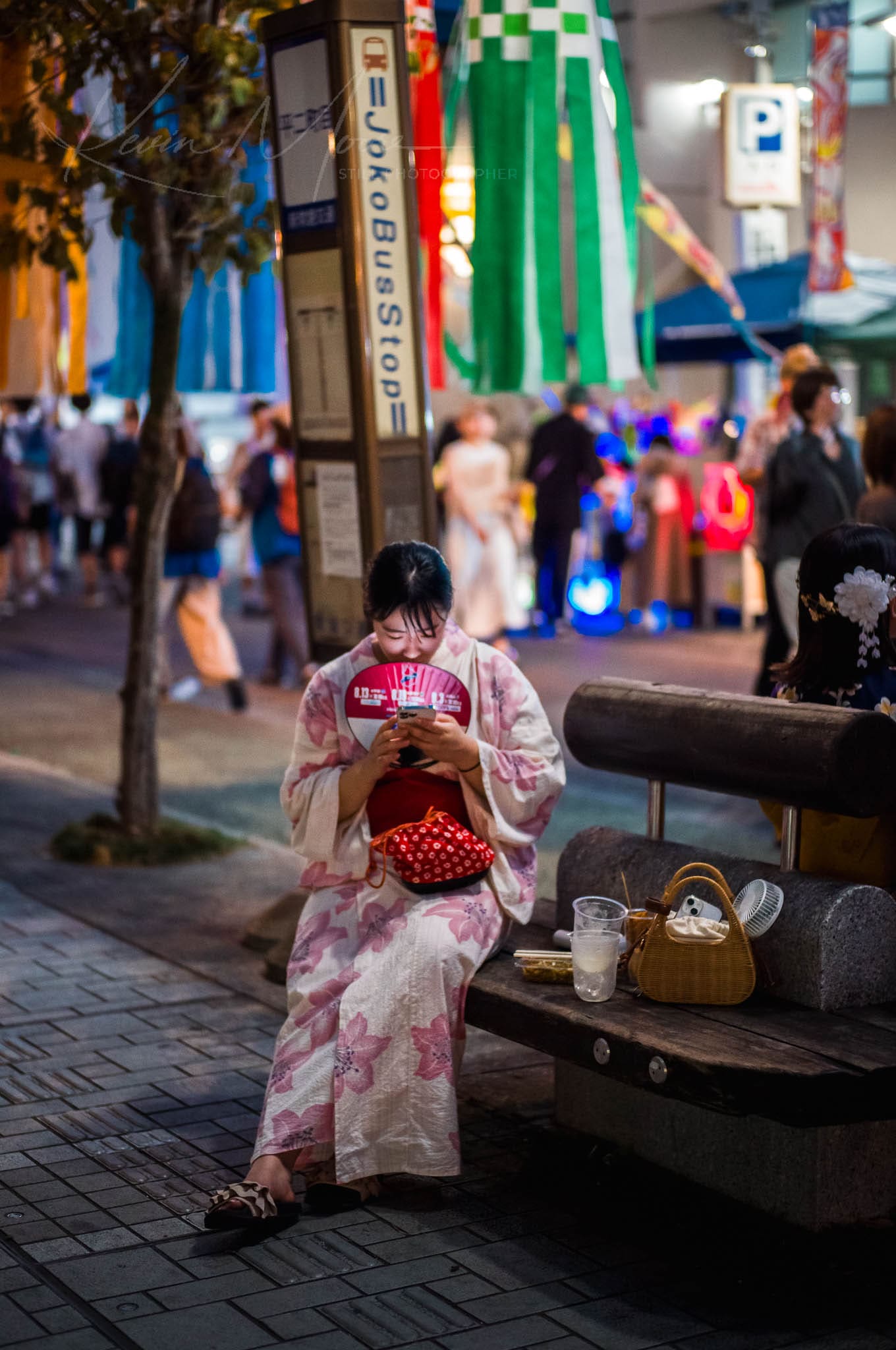 Woman in kimono interacting with handheld device, blending traditional Japanese heritage with modern urban life.
