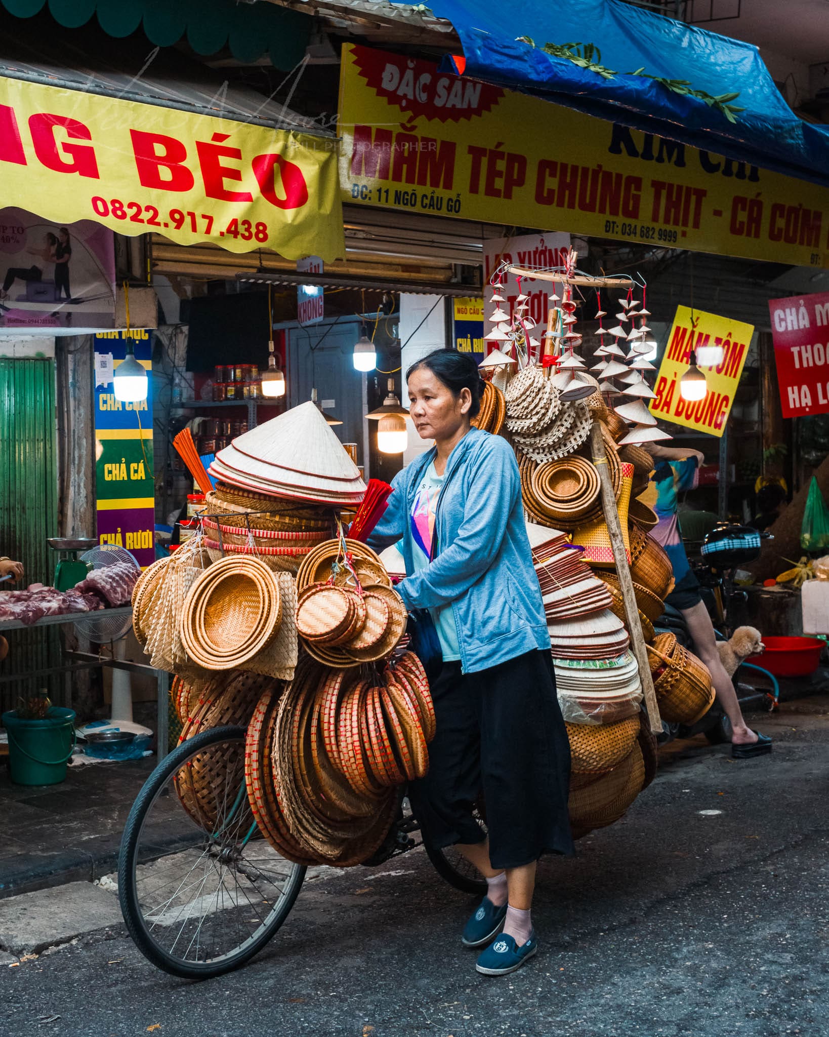  Hanoi market vendor with baskets on bicycle, showcasing traditional craftsmanship.