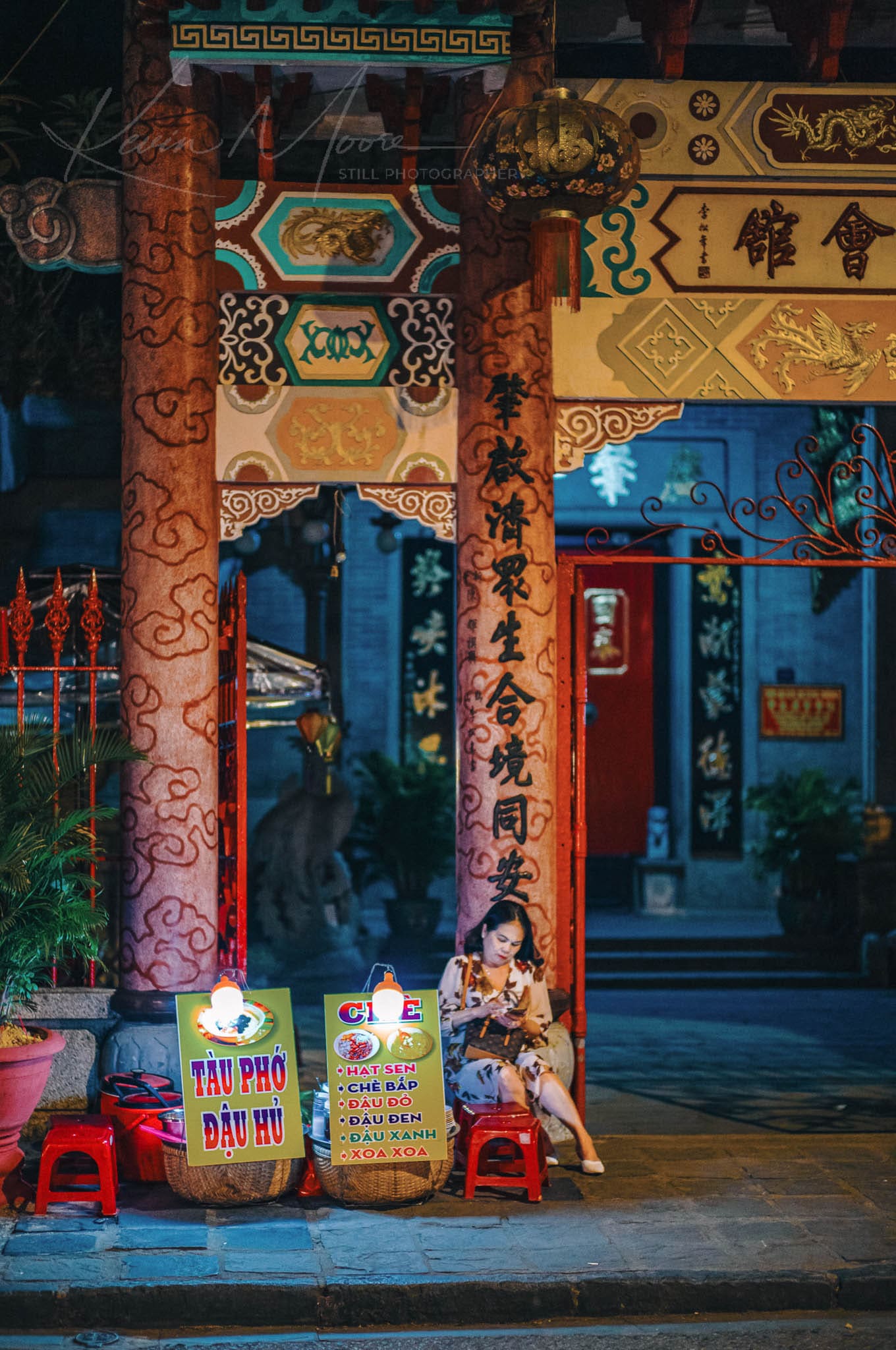 Vietnamese pho vendor at a traditional temple at night.
