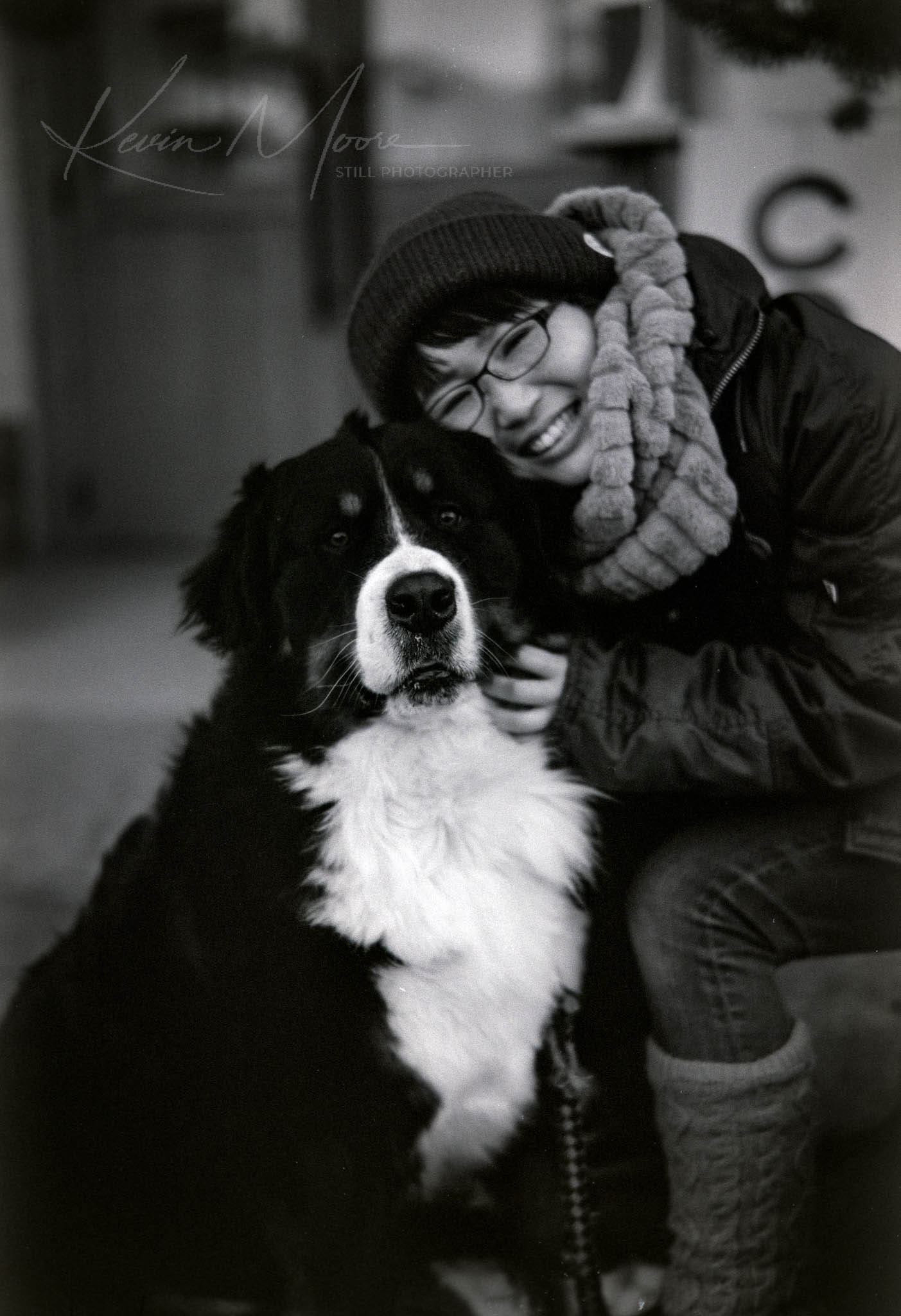 Woman sharing a loving moment with her Bernese Mountain Dog in an urban setting.