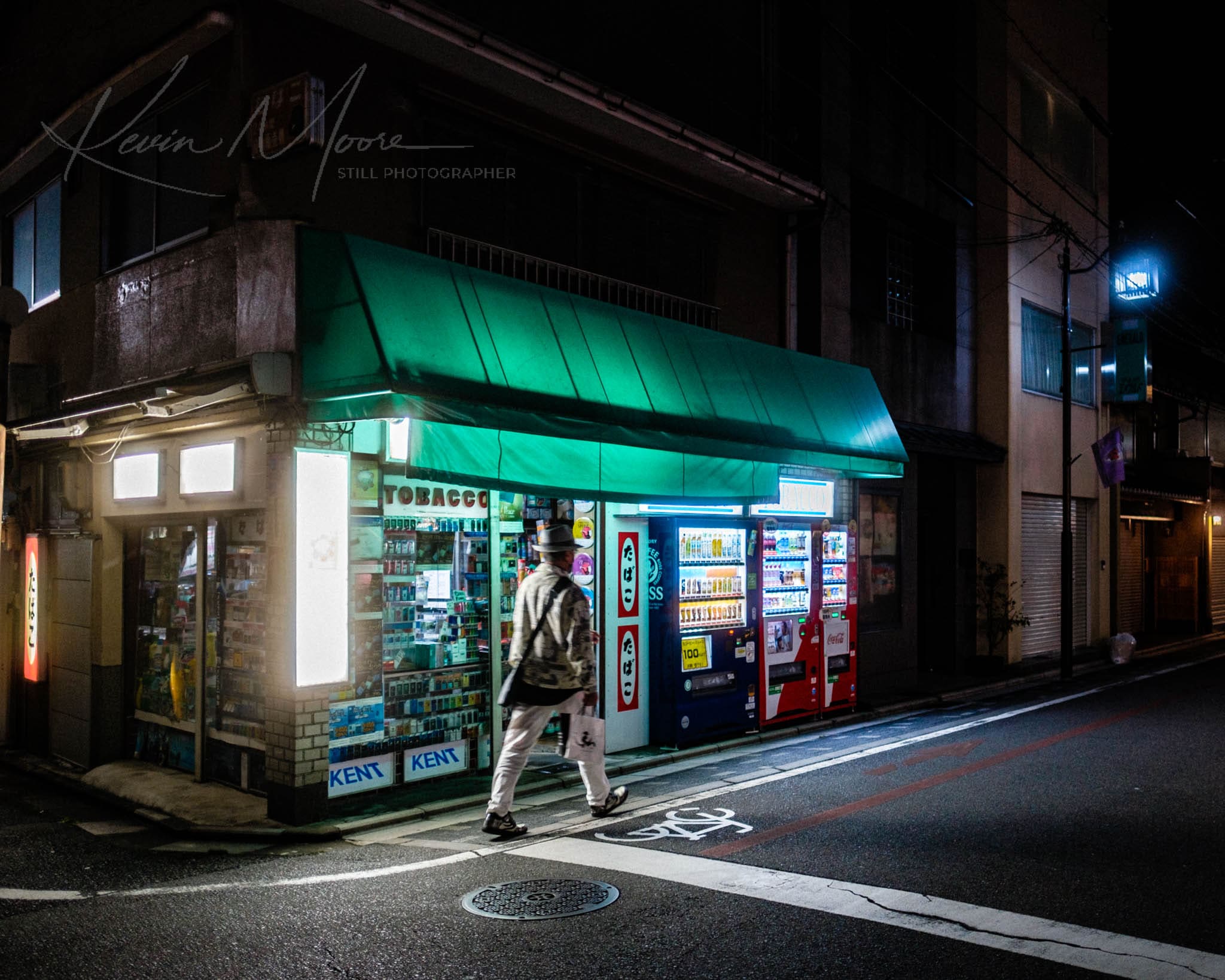 Lone pedestrian at brightly lit urban store on serene city night