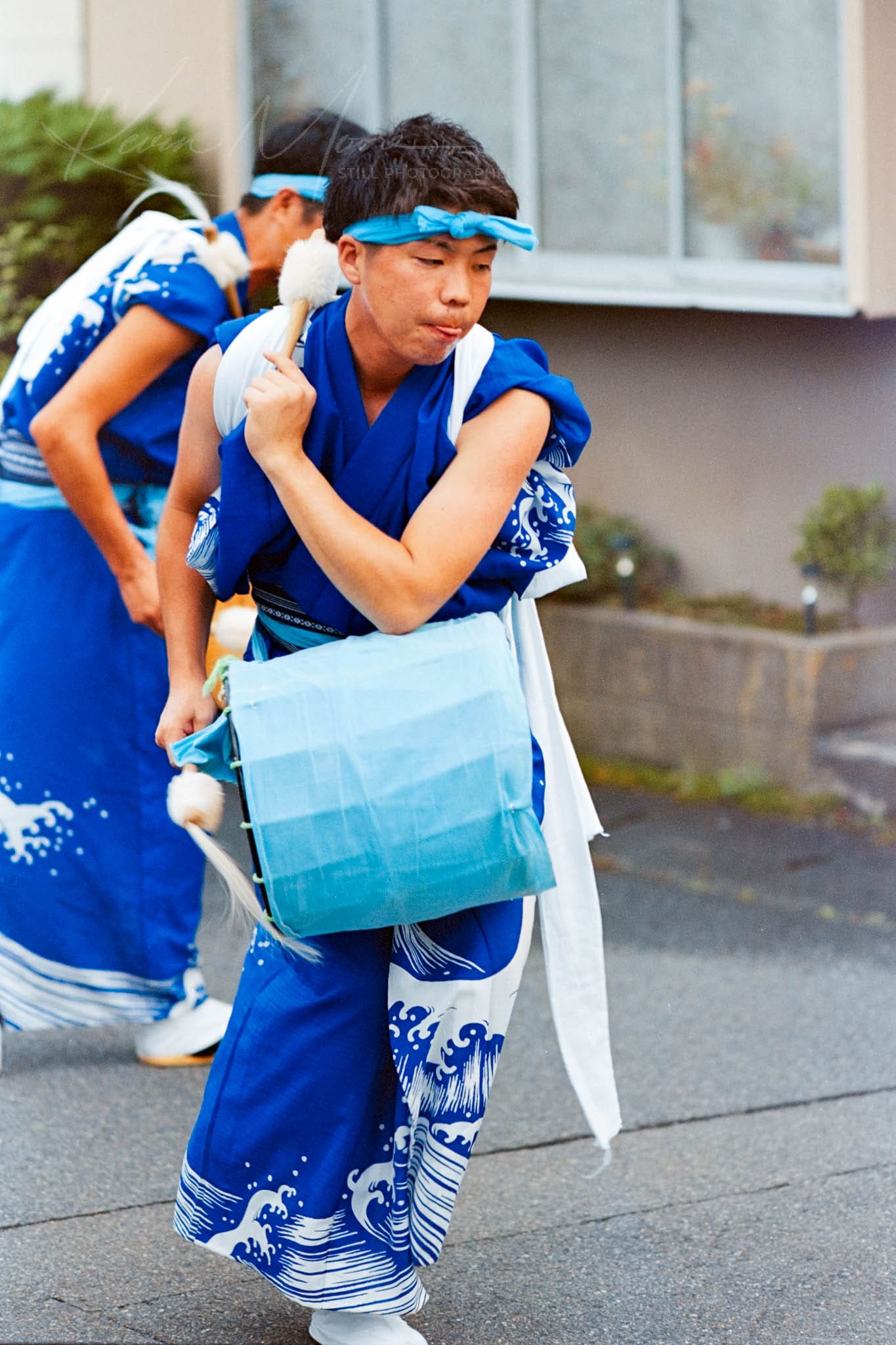 Taiko drummer in traditional Japanese attire performing at an outdoor festival