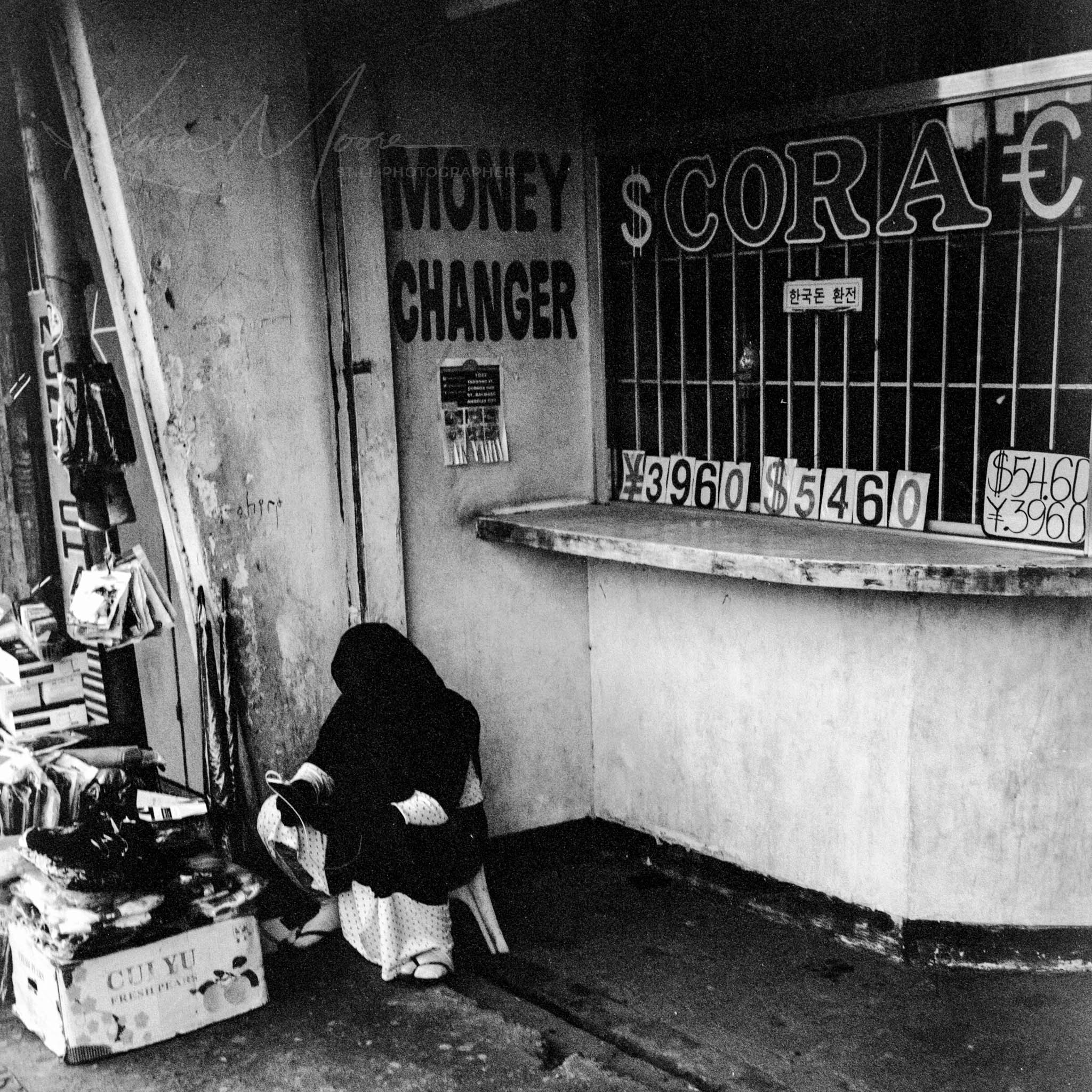 Unattended Money Exchange Booth and Homeless Person in Urban Setting