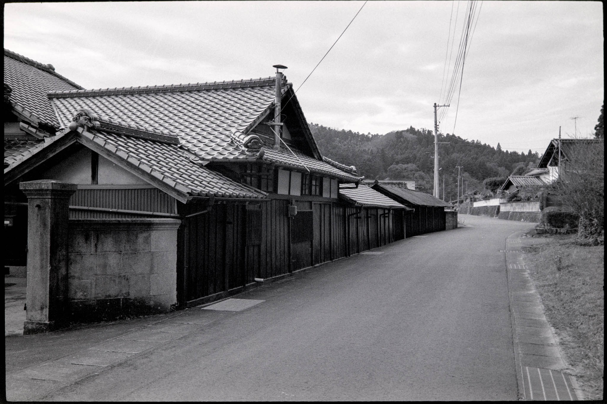 Black and white view of an empty, historic street lined with traditional houses.