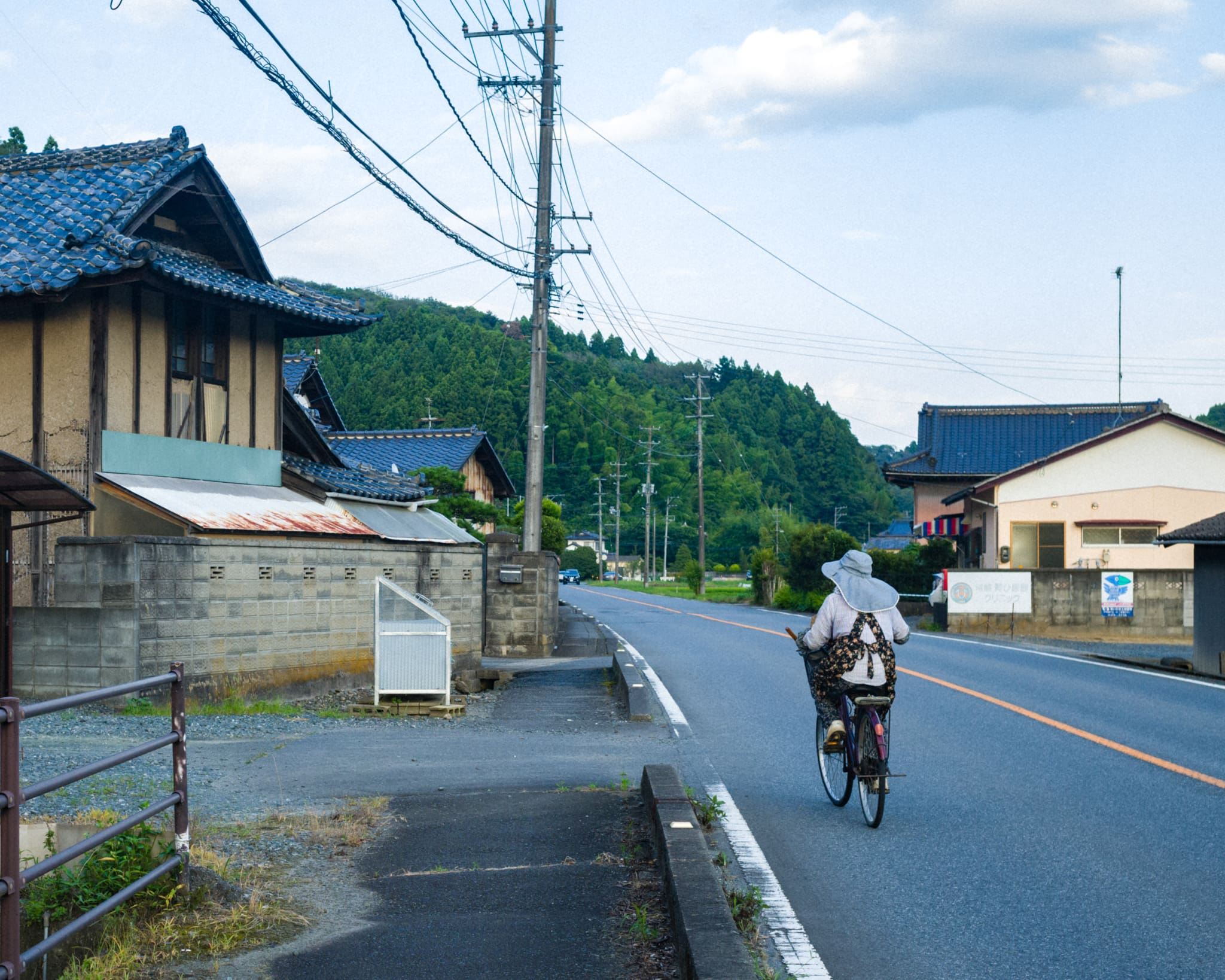 Cyclist enjoying a serene ride on a traditional Japanese rural street.