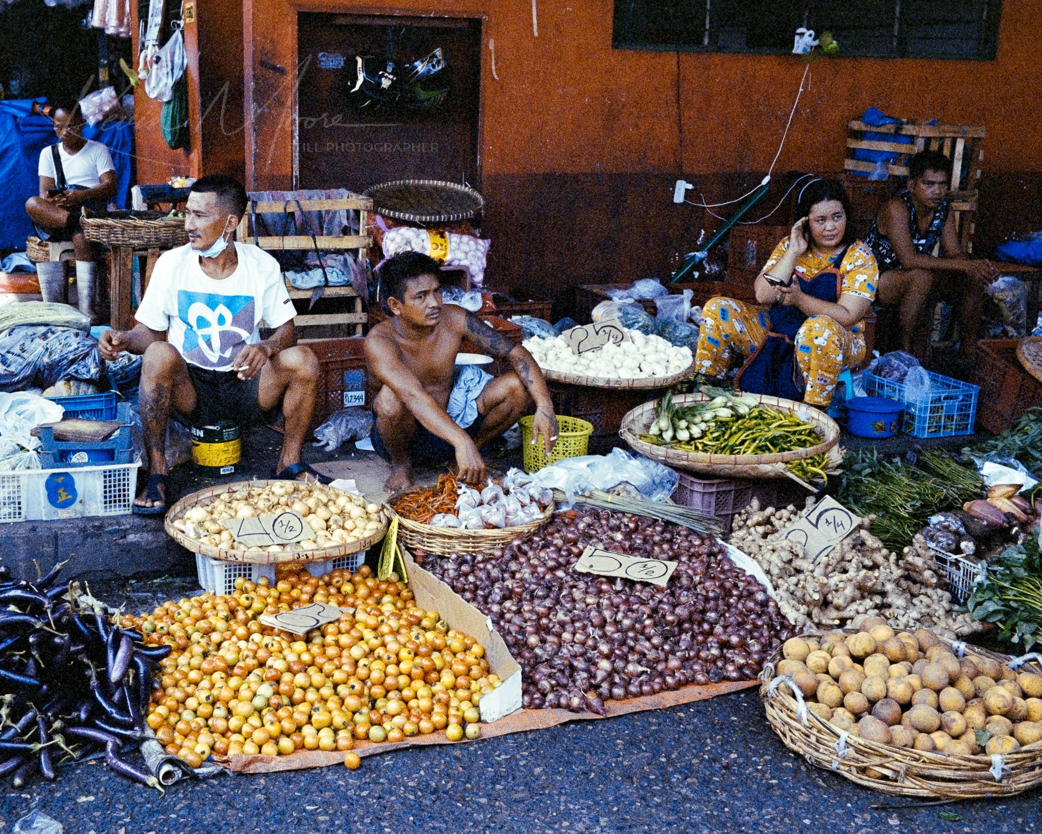 Local vendors at a vibrant, tropical street market selling fresh, colorful fruits and vegetables.