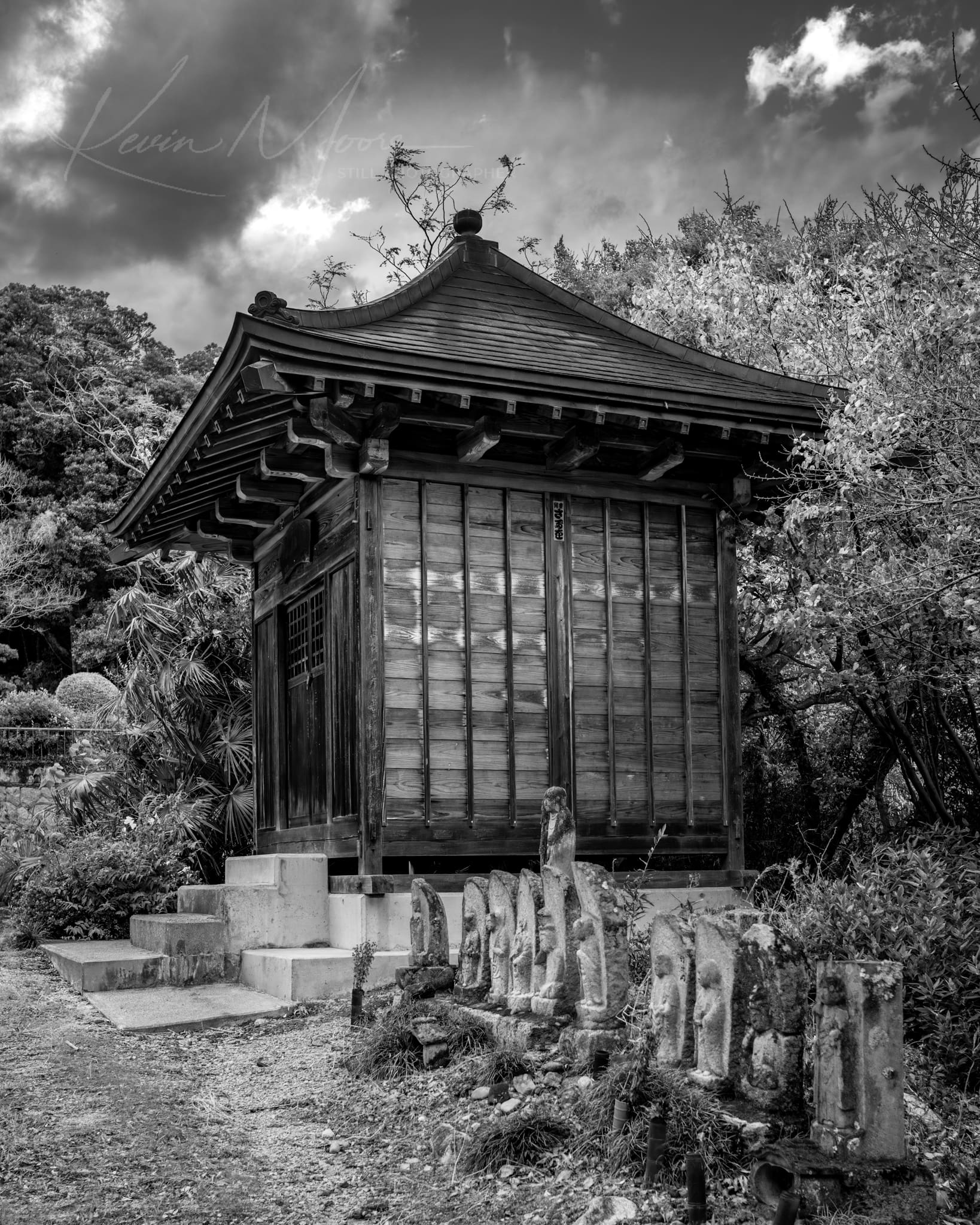 Black and white image of a serene Japanese garden with a traditional wooden pavilion.